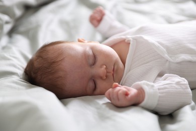 Photo of Cute newborn baby sleeping on bed, closeup