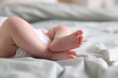Photo of Cute newborn baby lying on bed, closeup