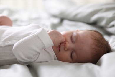 Photo of Cute newborn baby sleeping on bed, closeup