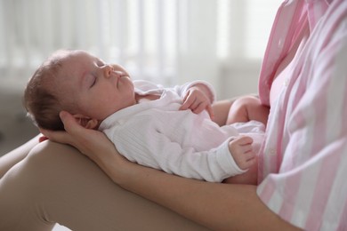 Photo of Mom holding her sleeping newborn baby at home, closeup