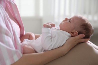 Photo of Mom holding her sleeping newborn baby at home, closeup