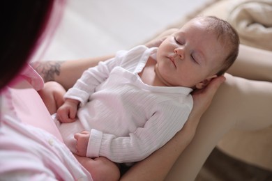 Photo of Mom holding her sleeping newborn baby at home, above view