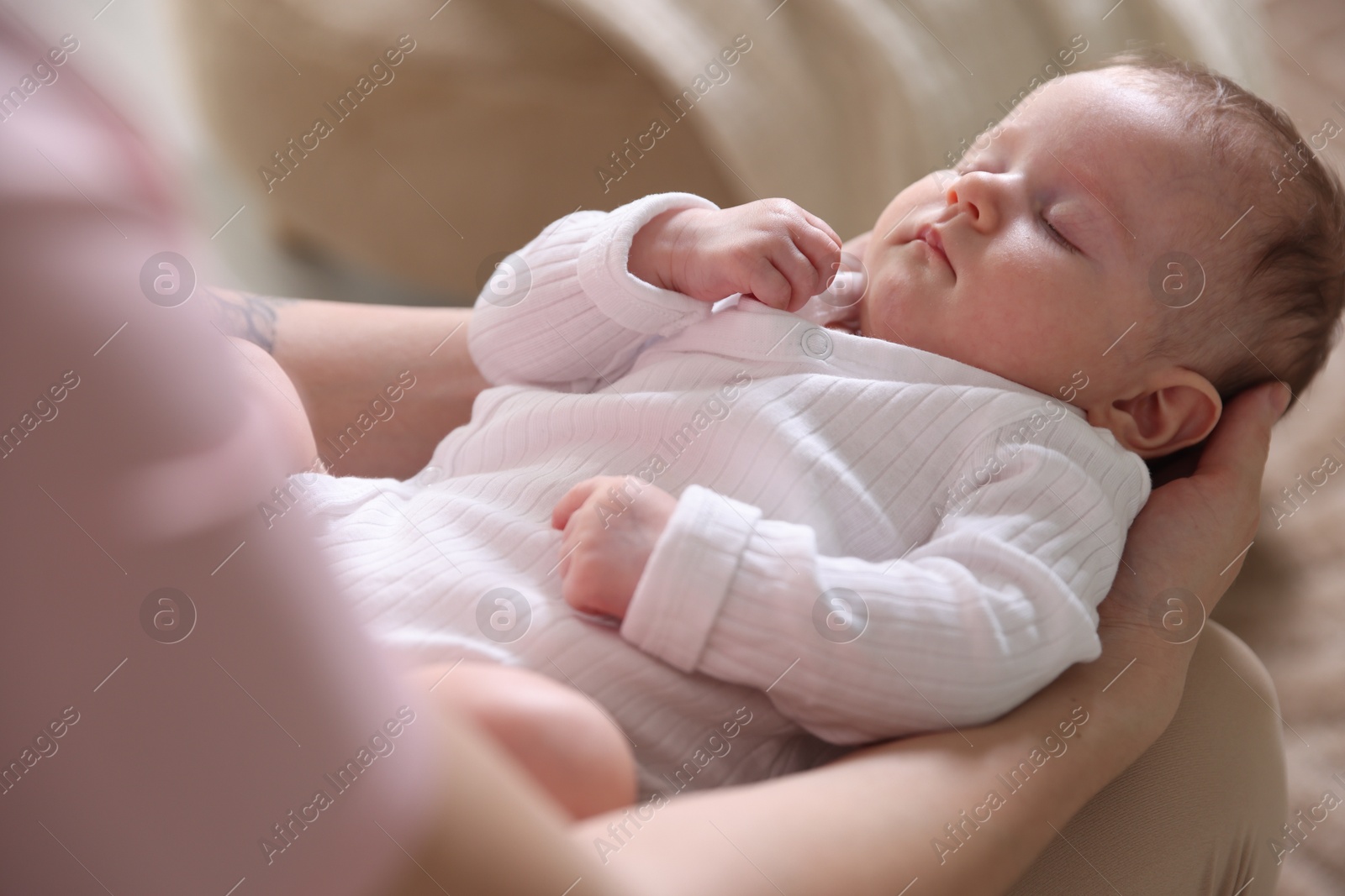 Mom holding her sleeping newborn baby at home, closeup Photo of Mom holding her sleeping newborn baby at home, closeup