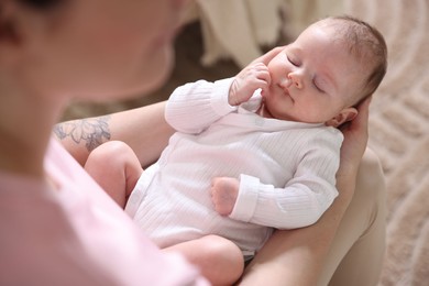 Photo of Mom holding her sleeping newborn baby at home, above view