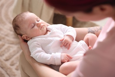 Photo of Mom holding her sleeping newborn baby at home, above view