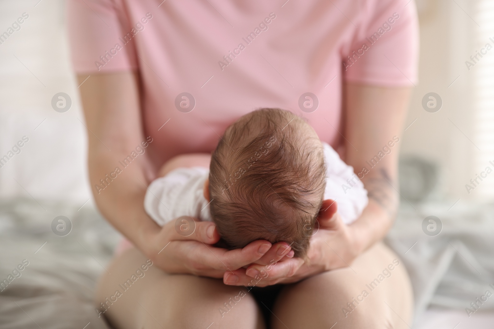 Mom holding her sleeping newborn baby at home, closeup Photo of Mom holding her sleeping newborn baby at home, closeup
