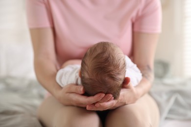 Photo of Mom holding her sleeping newborn baby at home, closeup