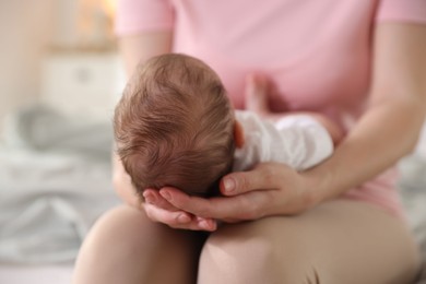 Photo of Mom holding her sleeping newborn baby at home, closeup