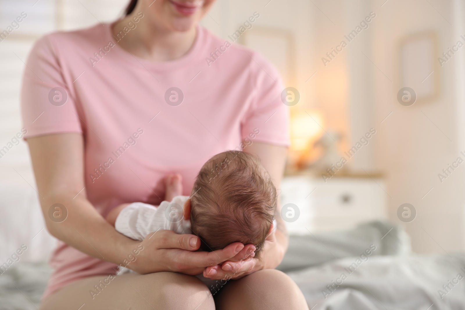 Mom holding her sleeping newborn baby at home, closeup Photo of Mom holding her sleeping newborn baby at home, closeup