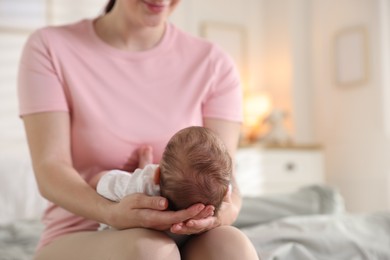 Photo of Mom holding her sleeping newborn baby at home, closeup