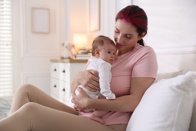 Photo of Mother putting her cute newborn baby to sleep on bed at home