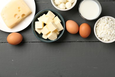 Photo of Different dairy products and eggs on grey wooden table, flat lay. Space for text