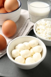Photo of Different dairy products and eggs on grey wooden table, closeup