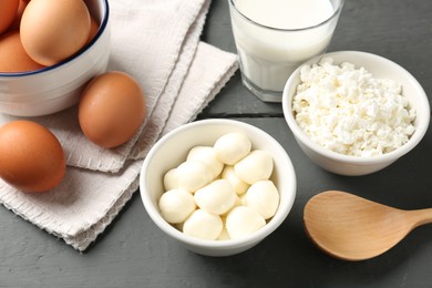 Photo of Different dairy products and eggs on grey wooden table, closeup