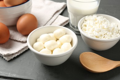 Photo of Different dairy products and eggs on grey wooden table, closeup