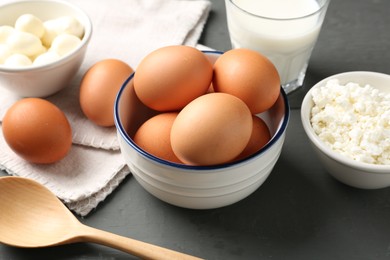 Photo of Different dairy products and eggs on grey wooden table, closeup