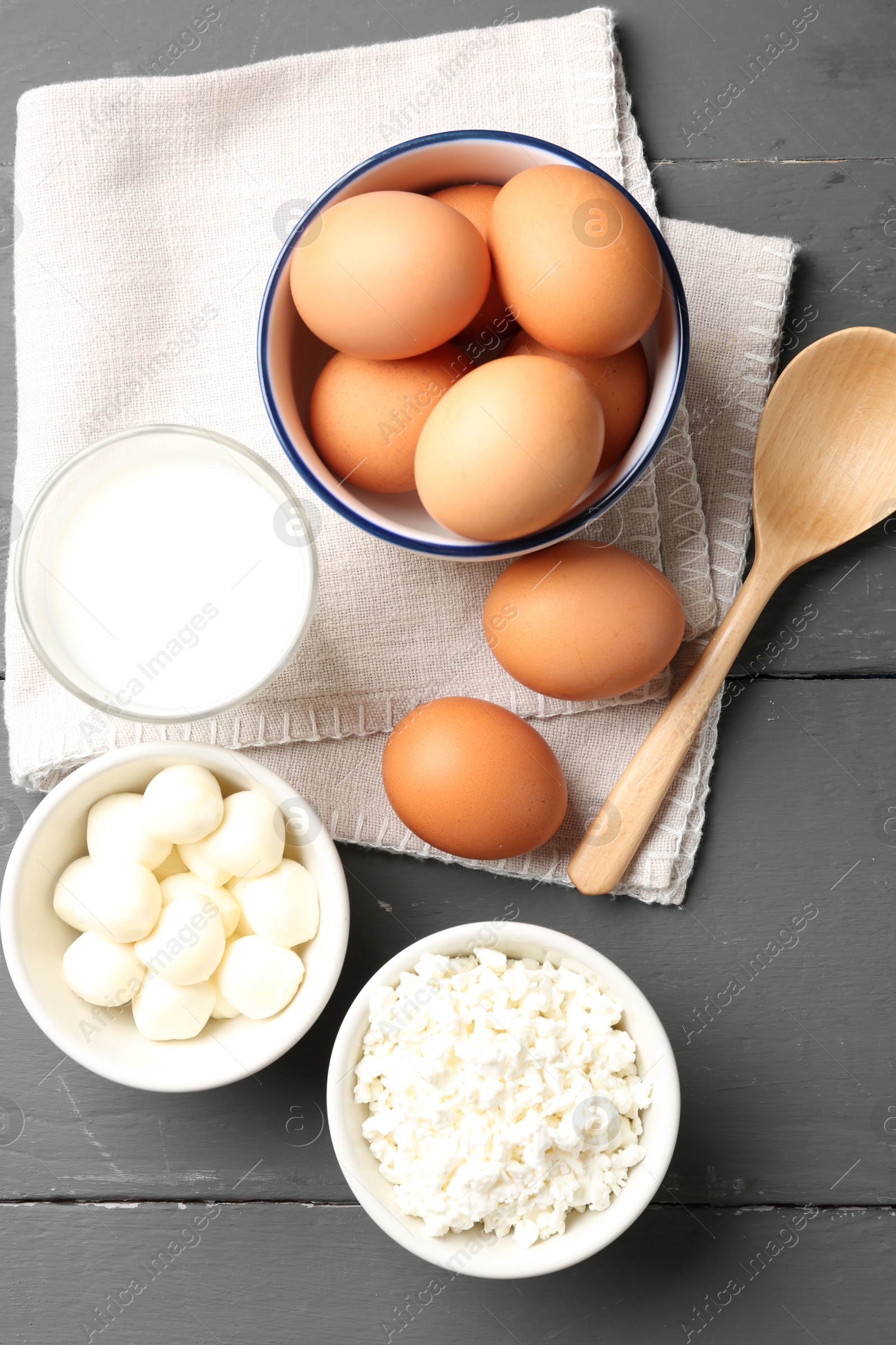 Different dairy products and eggs on grey wooden table, flat lay Photo of Different dairy products and eggs on grey wooden table, flat lay