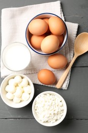 Photo of Different dairy products and eggs on grey wooden table, flat lay
