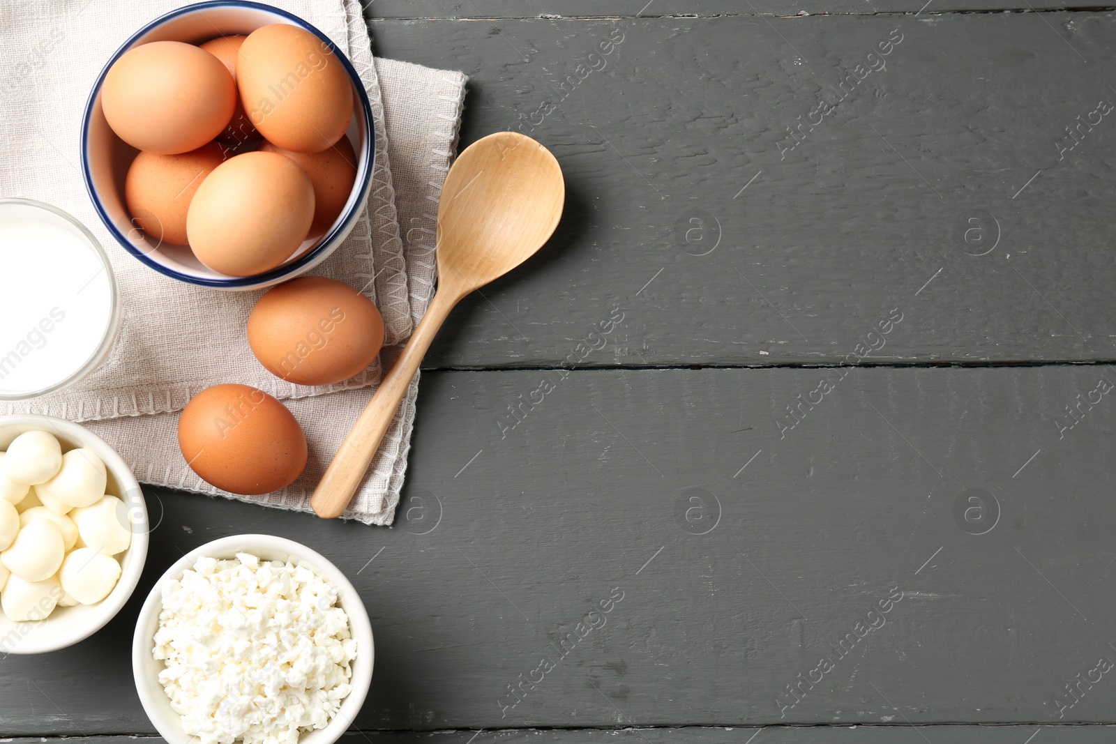 Different dairy products and eggs on grey wooden table, flat lay. Space for text Photo of Different dairy products and eggs on grey wooden table, flat lay. Space for text