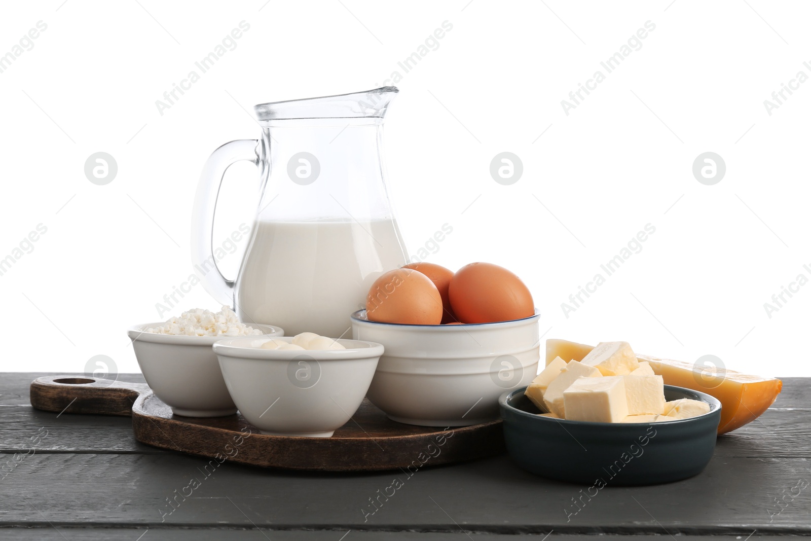 Different dairy products and eggs on grey wooden table against white background Photo of Different dairy products and eggs on grey wooden table against white background