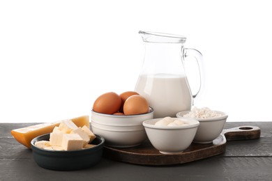 Photo of Different dairy products and eggs on grey wooden table against white background