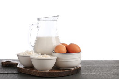 Photo of Different dairy products and eggs on grey wooden table against white background