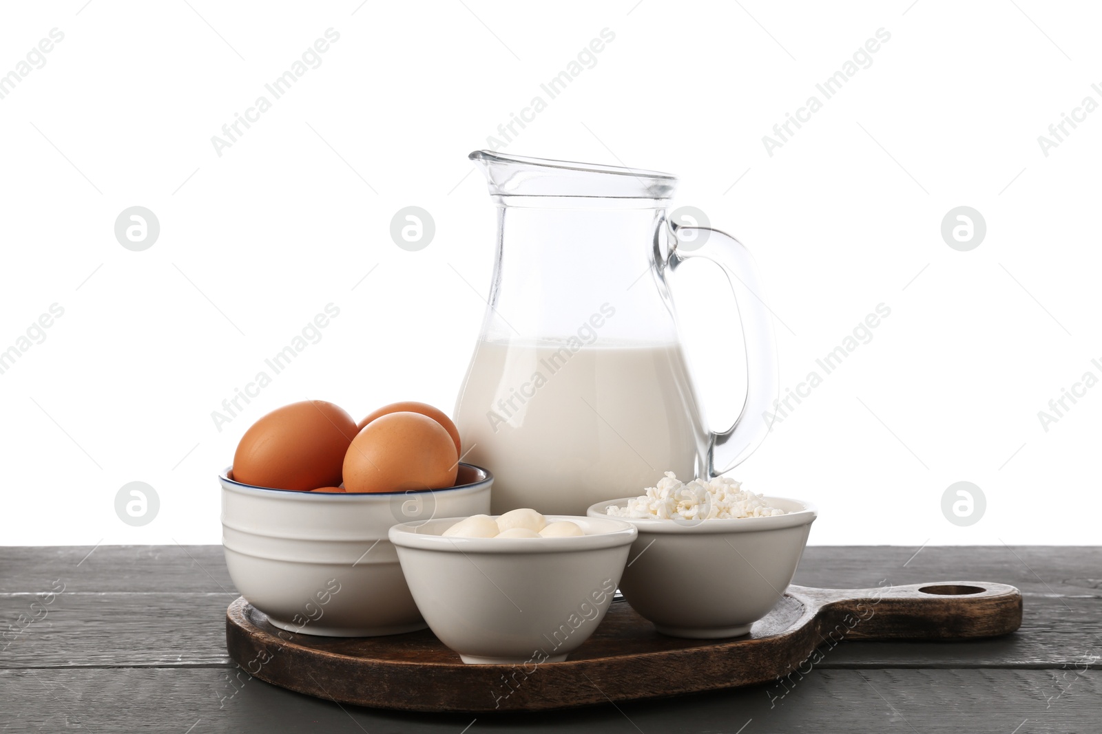 Different dairy products and eggs on grey wooden table against white background Photo of Different dairy products and eggs on grey wooden table against white background