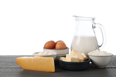 Photo of Different dairy products and eggs on grey wooden table against white background
