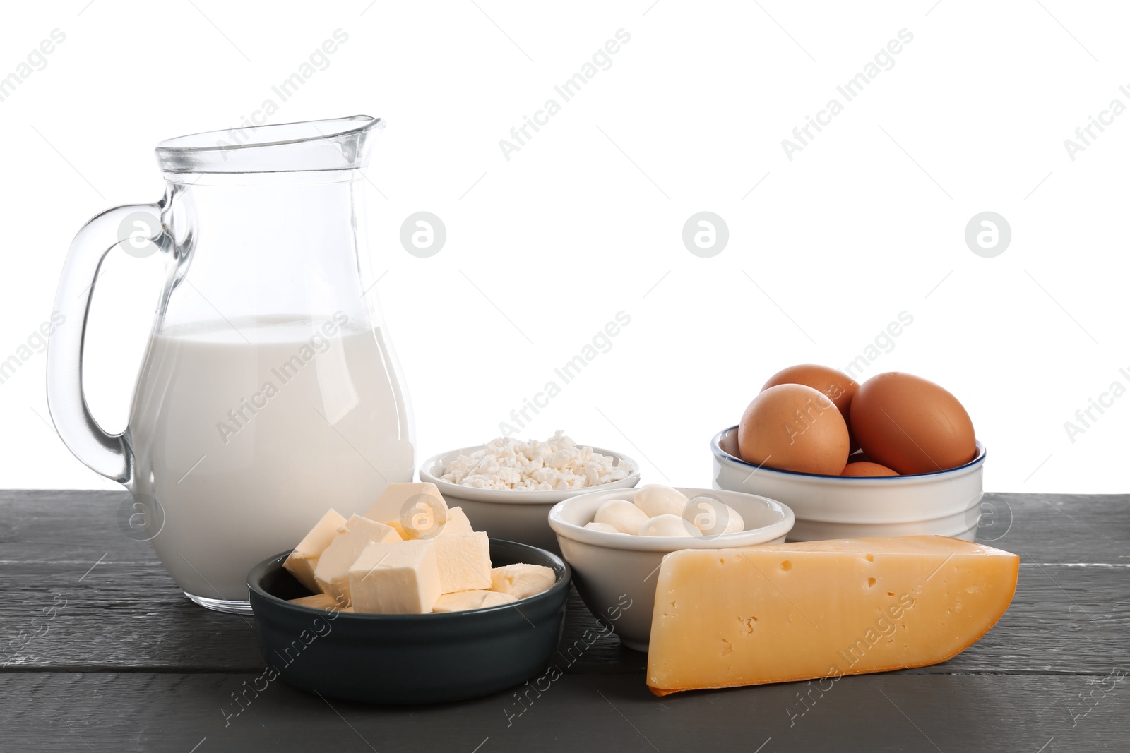 Different dairy products and eggs on grey wooden table against white background Photo of Different dairy products and eggs on grey wooden table against white background