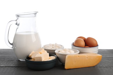 Photo of Different dairy products and eggs on grey wooden table against white background