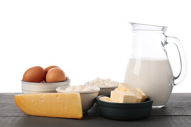 Photo of Different dairy products and eggs on grey wooden table against white background