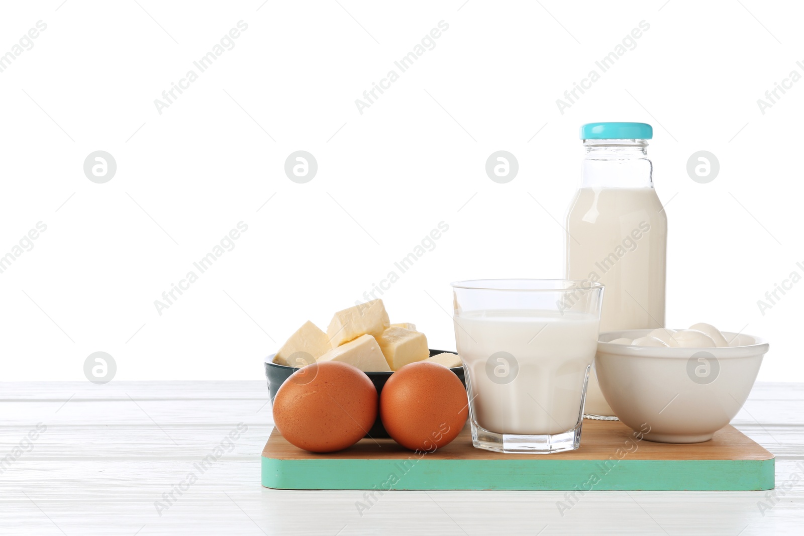 Different dairy products and eggs on wooden table against white background Photo of Different dairy products and eggs on wooden table against white background
