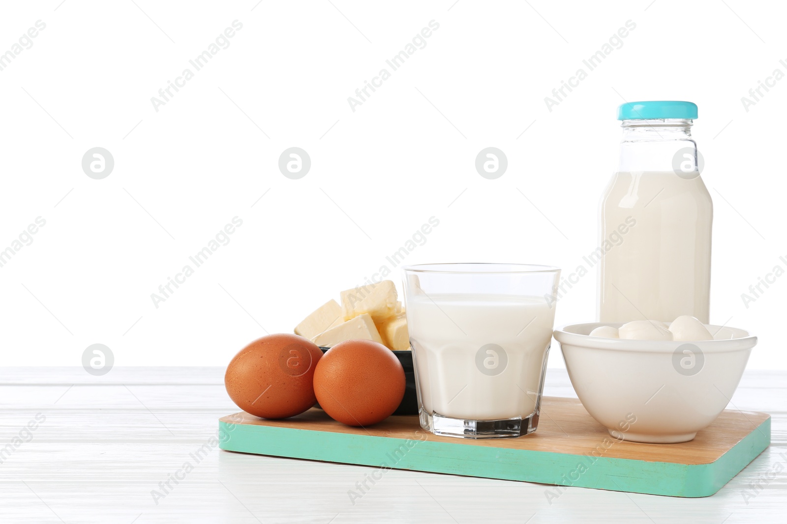 Different dairy products and eggs on wooden table against white background Photo of Different dairy products and eggs on wooden table against white background