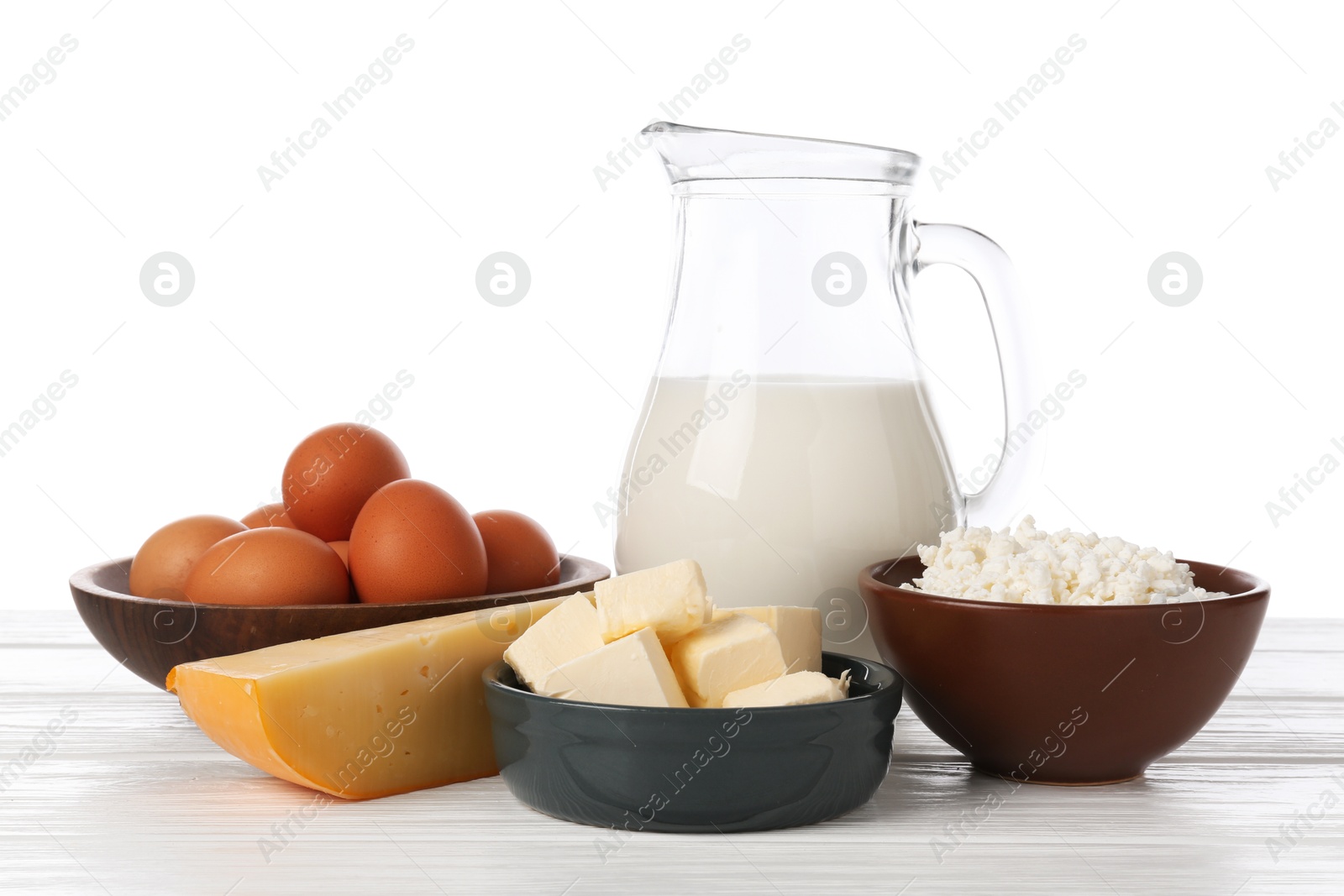 Different dairy products and eggs on wooden table against white background Photo of Different dairy products and eggs on wooden table against white background