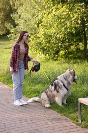 Photo of Happy woman with her cute Alaskan malamute dog in park