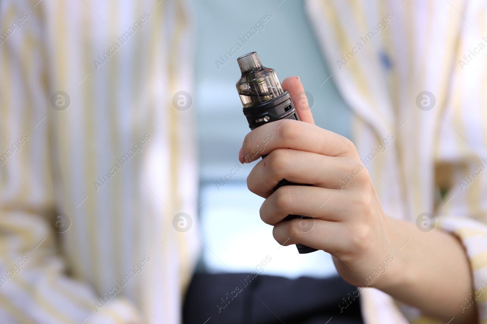 Young woman with electronic smoking device outdoors, closeup Photo of Young woman with electronic smoking device outdoors, closeup