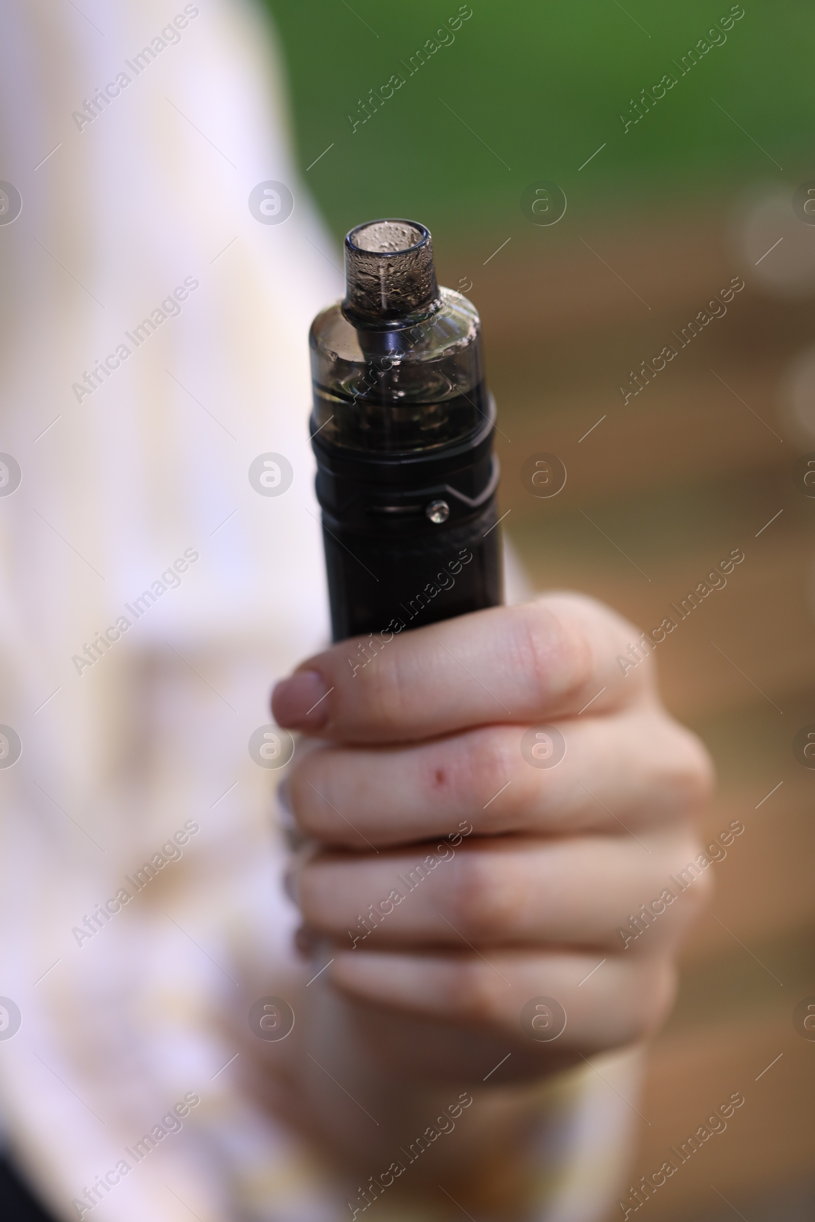 Young woman with electronic smoking device outdoors, closeup Photo of Young woman with electronic smoking device outdoors, closeup