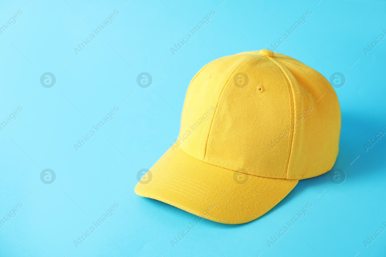 Yellow baseball hat on light blue background, space for text Photo of Yellow baseball hat on light blue background, space for text