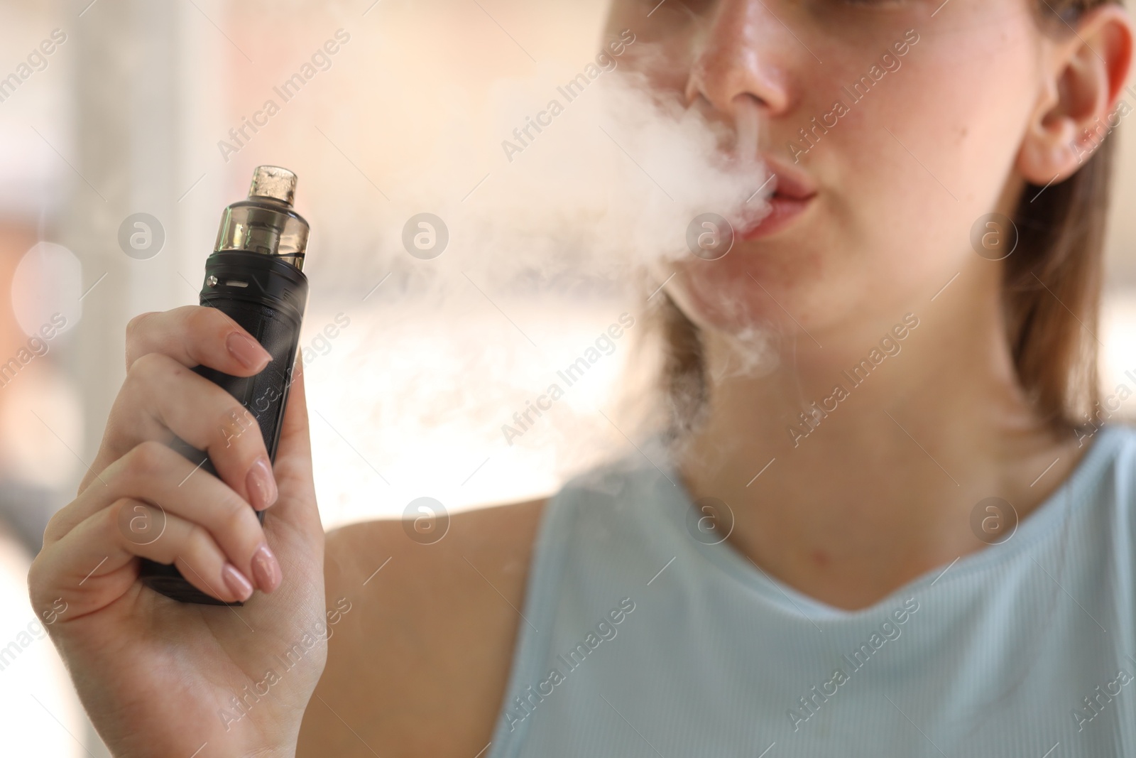 Young woman using electronic smoking device outdoors, closeup Photo of Young woman using electronic smoking device outdoors, closeup