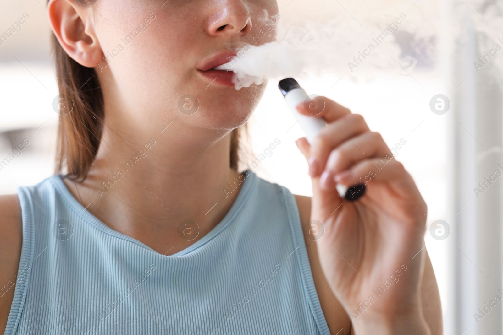 Young woman using electronic smoking device outdoors, closeup Photo of Young woman using electronic smoking device outdoors, closeup