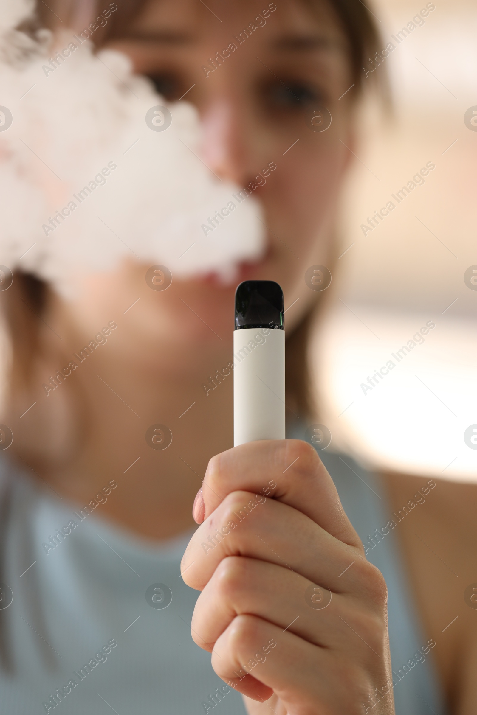Young woman using electronic smoking device outdoors, selective focus Photo of Young woman using electronic smoking device outdoors, selective focus