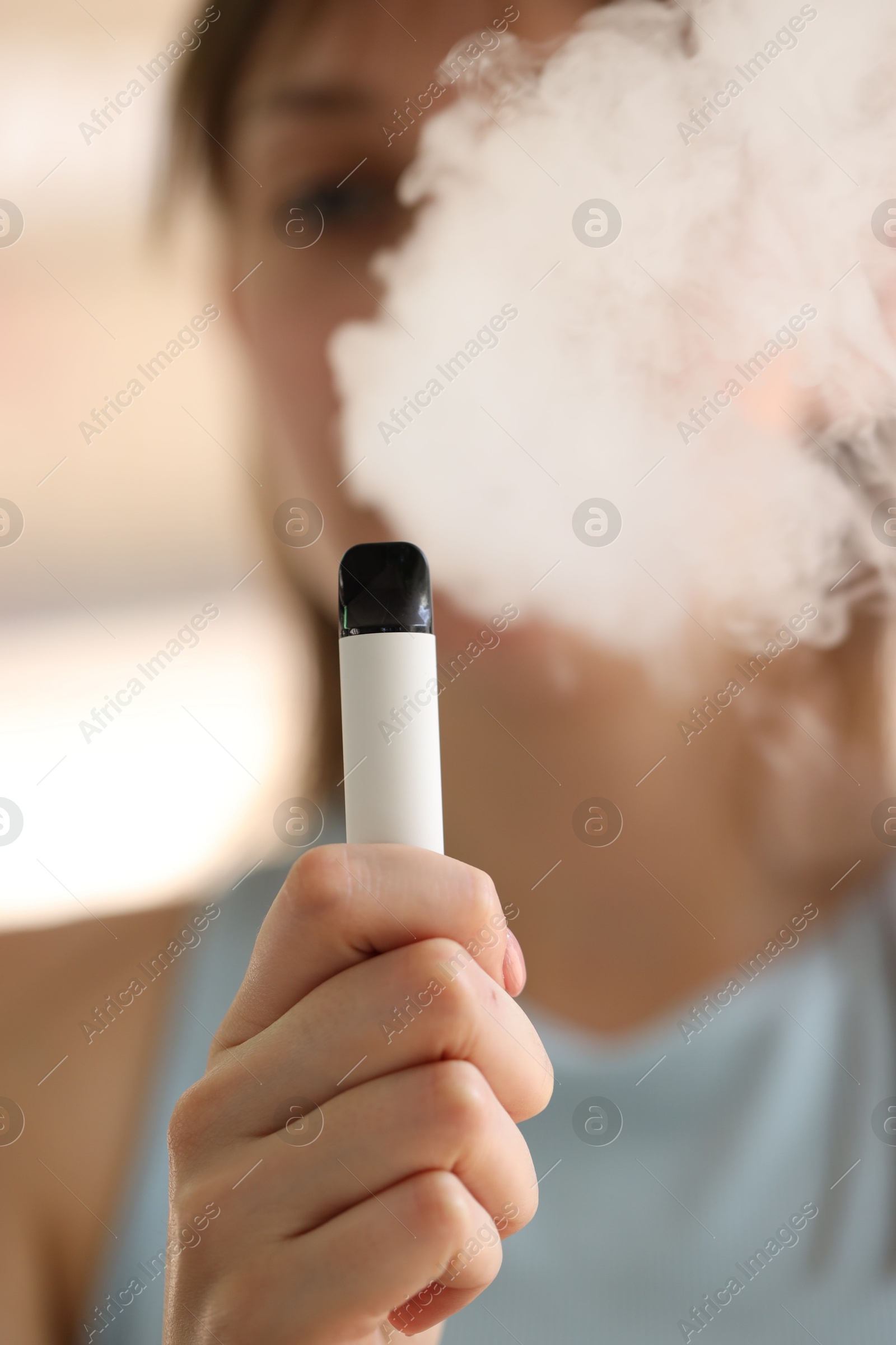 Young woman using electronic smoking device outdoors, selective focus Photo of Young woman using electronic smoking device outdoors, selective focus