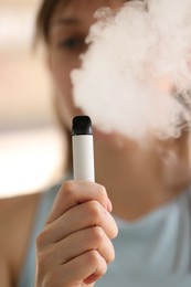 Photo of Young woman using electronic smoking device outdoors, selective focus