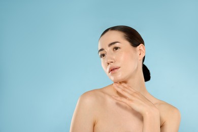 Photo of Beautiful woman after spa treatment on light blue background. Space for text
