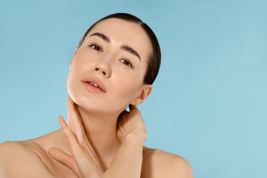 Photo of Beautiful woman after spa treatment on light blue background, closeup. Space for text