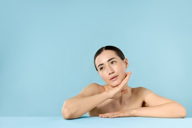 Photo of Beautiful woman after spa treatment on light blue background. Space for text