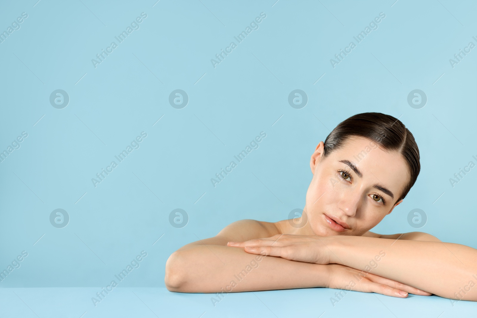 Beautiful woman after spa treatment on light blue background. Space for text Photo of Beautiful woman after spa treatment on light blue background. Space for text