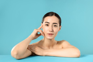 Photo of Portrait of beautiful woman after spa treatment on light blue background