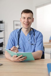 Photo of Medical student in uniform studying at desk indoors