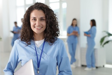 Photo of Medical student in uniform with laptop indoors, selective focus